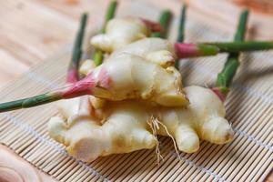 Young ginger slice for herb medicinal natural and food - Fresh ginger root harvest on wood photo