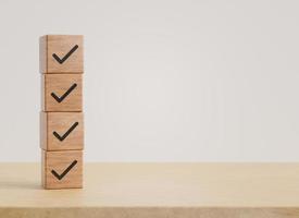 Wood cube with check mark with copy space on wooden floor background. business concept, 3D rendering. photo