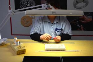 Female worker in Majorca Pearls factory making pearl necklace. photo