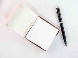 Note pad and black pen on a white background. photo