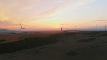 vista estática aérea cinco turbinas eólicas em campo verde com panorama de fundo do céu bonito. copiar e colar o fundo do conceito de energia renovável