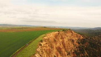 Aerial view down to 4wd vehicle going up the hill with surreal landscape of hills in VAshlovani national park video