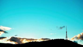 Zeitraffer Tiflis Fernsehturm-Silhouette bei Sonnenuntergang mit blauem, leerem Himmelshintergrund video