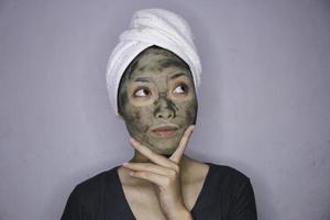 Asian woman was thinking and day dreaming when she use beauty face mask photo