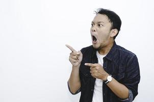 Young asian man is surprised and shouting wow with pointing right with his hand isolated on gray background. photo