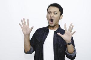 Young asian man is surprised and shouting wow with pointing right with his hand isolated on gray background. photo
