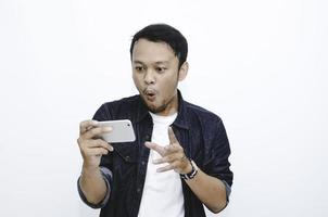 Wow face of Young Asian man shocked and surprised when he play on smartphone. photo