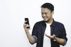 Smile and happy face of Young Asian man when playing game at phone in hand. photo