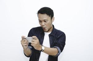 Wow face of Young Asian man shocked and surprised when he play on smartphone. photo