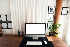 escritorio de oficina en casa, pantalla de computadora en una mesa de madera en la casa foto