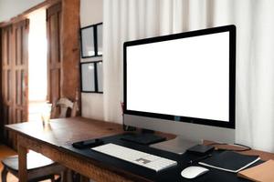 escritorio de oficina en casa, pantalla de computadora en una mesa de madera en la casa foto