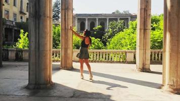vue de suivi une touriste caucasienne prend une photo dans un monument historique pittoresque seul, profitez d'un voyage en solo.