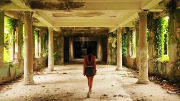 Tracking-Ansicht Junge weibliche Touristen gehen um das verlassene alte Tsqaltubo-Spa-Resort-Gebäude aus der Sowjetzeit herum. Architekturgebäude der UdSSR in Georgien. video