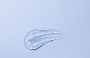 Thick transparent gel cosmetic soap texture, antiseptic, hyaluron on blue top view photo