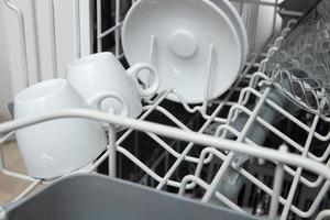 White dishes in the dishwasher. Homework with dishwasher concept photo