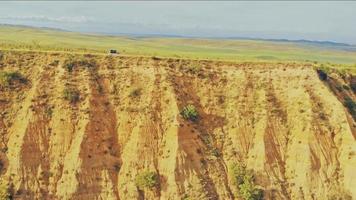 dronepiloot in bewegend 4wd-voertuig bestuurt drone op de voorstoel vanuit luchtperspectief op een schilderachtige locatie buitenshuis video