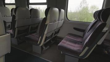 lege stoelen in de trein met uitzicht op de vilniustoren door het raam. litouwen openbaar vervoer per spoor concept. video