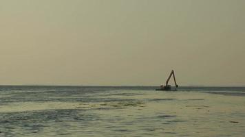 escavadeira trabalhando no mar remoção de poluição marinha video