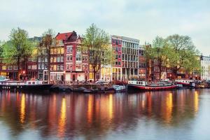 Canal houses of Amsterdam at dusk with vibrant reflections, Neth photo