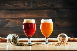 Two glasses of beer on a wooden table grains photo