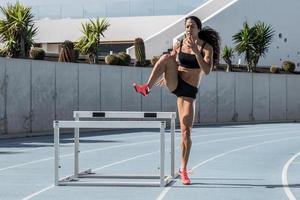 mujer joven y atlética entrenando en pista de atletismo foto