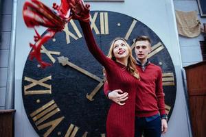 Portrait of beautiful stylish couple standing near the clock. A photo