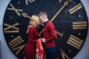 Portrait of beautiful stylish couple standing near the clock. A photo