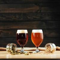 Two glasses of beer on a wooden table grains photo