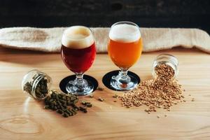 dos vasos de cerveza en una mesa de madera granos foto