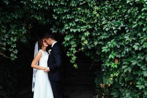 beautiful young wedding couple kissing , blonde bride with flowe photo