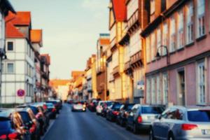 Cars parked along cobblestone way. Natural blurred background. photo