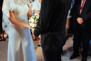 newlywed couple on the wedding day with bouquet in hand photo