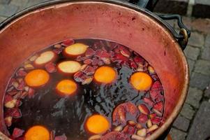 Copper pot with hot wine and fruit photo