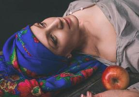 Sad mature woman in ukrainian national headdress with apple photo