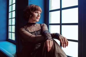 woman in vintage dress indoor by the window photo