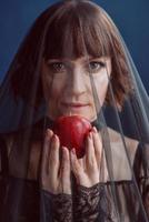 bella mujer bruja con manzana roja venenosa foto