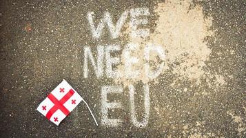 Georgian flag lay on ground by written statement we need EU. Integration process to EU concept photo