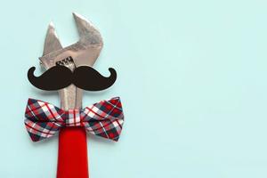 Happy Fathers Day. Top view of wrench with bow tie and false mustache with copy space. Fathers Day celebration concept photo