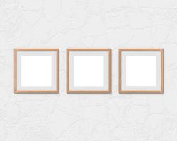 Set of 3 square wooden frames mockup with a border hanging on the wall. Empty base for picture or text. 3D rendering. photo