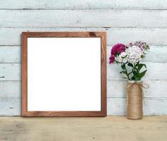Square Old Wooden Frame mockup near a bouquet of sweet-william  stands on a wooden table on a painted white wooden background. Rustic style, simple beauty. 3d render. photo