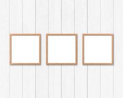 Set of 3 square wooden frames mockup hanging on the wall. Empty base for picture or text. 3D rendering. photo