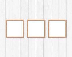 Set of 3 square wooden frames mockup hanging on the wall. Empty base for picture or text. 3D rendering. photo