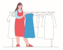 Pregnant woman in the store chooses a dress. Maternity clothes. Rack with dresses