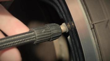 neumático inflado. la mano del hombre abre la tapa de la válvula e infla el neumático del camión antes de conducir. video