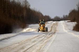 grader at work on logging road in winter photo