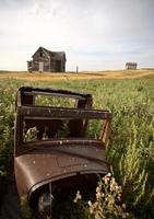 Abandoned old vehicle and farm house in Saskatchewan photo