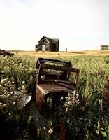 vehículo antiguo abandonado y casa de campo en saskatchewan foto