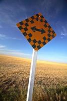 Road sign in front of a combined Saskatchewan field photo