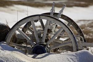 Old wooden wagon wheels in snow photo