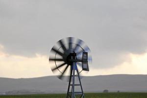 Spinning windmill in scenic Saskatchewan photo